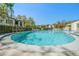 Sparkling community pool with lounge chairs surrounded by lush landscaping and nearby condominiums at 700 Starkey Rd # 1111, Largo, FL 33771