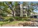 Multi-story condominium with balconies surrounded by lush greenery and mature shade trees at 700 Starkey Rd # 1111, Largo, FL 33771
