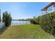 Green backyard with lake views and a partial view of the home's exterior at 7304 Egypt Lake Dr, Tampa, FL 33614