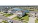 Picturesque aerial view of a two-story home with a well-maintained lawn, situated near a tranquil lake at 7811 Roma Dune Dr, Wesley Chapel, FL 33545