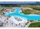 An aerial view of the lagoon and beachfront with chairs and umbrellas at 7811 Roma Dune Dr, Wesley Chapel, FL 33545