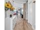 Inviting entryway with wood floors, a white dresser, and sunflowers, creating a warm and welcoming atmosphere at 7811 Roma Dune Dr, Wesley Chapel, FL 33545