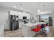 A modern kitchen featuring white cabinets, a large center island with seating, and stainless steel appliances at 7811 Roma Dune Dr, Wesley Chapel, FL 33545