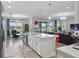 Open-concept kitchen with a view of the living room, features a center island, and modern stainless appliances at 7811 Roma Dune Dr, Wesley Chapel, FL 33545