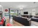 The open-concept living room has a view of the screened-in porch and features wood flooring, an aquarium, and a chandelier at 7811 Roma Dune Dr, Wesley Chapel, FL 33545