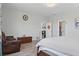 Bright main bedroom featuring a comfortable chair, wood floors, and elegant furnishings at 7811 Roma Dune Dr, Wesley Chapel, FL 33545