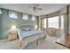 Bright bedroom features a ceiling fan, large windows, and blue accents at 8141 Ambersweet Pl, Land O Lakes, FL 34637