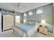 Comfortable bedroom with a blue patterned bedspread, ceiling fan, and decorative accents at 8141 Ambersweet Pl, Land O Lakes, FL 34637