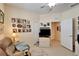 Bright bedroom with a wall of Gathering photos, a TV on a dresser, and open doorway at 8141 Ambersweet Pl, Land O Lakes, FL 34637