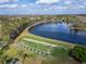 Scenic aerial view of a large lake with a manicured lawn and golf practice area on a sunny day at 8141 Ambersweet Pl, Land O Lakes, FL 34637