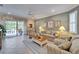 Well-lit living area featuring tile flooring, a sliding glass door to the outside, and cozy furniture at 8141 Ambersweet Pl, Land O Lakes, FL 34637