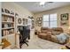 Functional office space with built-in bookshelves and cabinets and a comfortable recliner at 8141 Ambersweet Pl, Land O Lakes, FL 34637