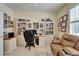 Functional office space with built-in bookshelves and cabinets and a comfortable recliner at 8141 Ambersweet Pl, Land O Lakes, FL 34637