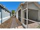 View of the brick paved patio through a screened doorway, showing the exterior walkway at 8141 Ambersweet Pl, Land O Lakes, FL 34637