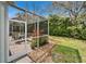 Relaxing screened-in patio with decorative brickwork, lush greenery, and plenty of natural light at 8141 Ambersweet Pl, Land O Lakes, FL 34637