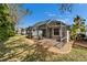 Screened-in patio with brick flooring and outdoor seating overlooking the well-maintained lawn at 8141 Ambersweet Pl, Land O Lakes, FL 34637