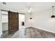 Bedroom featuring polished concrete floors, ceiling fan, and a modern sliding barn door at 8448 Flagstone Dr, Tampa, FL 33615