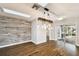 Modern dining room featuring rustic lighting and wood accent wall, leading to the outdoors at 8448 Flagstone Dr, Tampa, FL 33615