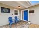 Inviting front porch featuring blue Adirondack chairs and a brightly colored front door at 8448 Flagstone Dr, Tampa, FL 33615