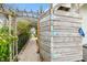 Side view of the outdoor shower with an arbor and walkway surrounded by lush landscaping at 8448 Flagstone Dr, Tampa, FL 33615