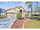 Charming single-story home featuring a well-manicured lawn, red door, and a lovely palm tree at 8534 Carriage Pointe Dr, Gibsonton, FL 33534