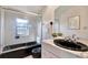 Bathroom with shower and black fixtures with a marble countertop and a decorative art piece at 9222 134Th St, Seminole, FL 33776