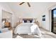 A modern bedroom with vaulted ceilings, a ceiling fan, two matching bedside tables and lamps, and access to an outdoor porch at 9222 134Th St, Seminole, FL 33776