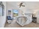 Bright bedroom with a ceiling fan, a plush bed, an accent chair, and a view to the outdoors at 9222 134Th St, Seminole, FL 33776