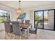 Elegant dining room with chandelier, table with upholstered chairs, and sliding glass door to deck at 9222 134Th St, Seminole, FL 33776