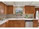 Well-lit kitchen with a double sink, classic oak cabinetry, and tiled backsplash at 9222 134Th St, Seminole, FL 33776