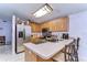 Well-lit kitchen with wooden cabinets, stainless steel appliances, and a breakfast bar with seating at 9319 Ashfield Ct, Tampa, FL 33615