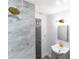 This bathroom features modern shower tile, a vanity and gold fixtures at 9607 N 13Th St, Tampa, FL 33612