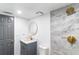 Well-lit bathroom featuring stylish gray door, shower, vanity with gold fixtures, and a large mirror at 9607 N 13Th St, Tampa, FL 33612