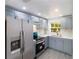 Modern kitchen featuring stainless steel appliances, light blue cabinets, quartz countertops, and a window at 9607 N 13Th St, Tampa, FL 33612