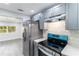 Well-equipped kitchen featuring stainless steel appliances, gray cabinets, and mosaic backsplash at 9607 N 13Th St, Tampa, FL 33612