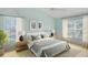 This bright bedroom is staged with a king bed and two windows at 10302 Belltower St, Spring Hill, FL 34608