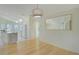 Bright dining area with modern lighting, view to the kitchen, and white wainscoting at 10302 Belltower St, Spring Hill, FL 34608