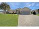 Charming one-story home featuring a paver driveway, lush lawn, and a two-car garage at 10302 Belltower St, Spring Hill, FL 34608