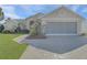 Charming single-story home with a large driveway, well-manicured lawn, and lush landscaping at 10302 Belltower St, Spring Hill, FL 34608