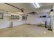 Well-lit two-car garage with built-in cabinets, shelving, and a utility sink, providing ample storage and workspace at 10302 Belltower St, Spring Hill, FL 34608
