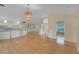 Open-concept living room with light wood floors and a modern, woven light fixture at 10302 Belltower St, Spring Hill, FL 34608