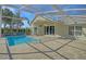 Relaxing pool area with a screened enclosure, patio space, and lush landscaping at 10302 Belltower St, Spring Hill, FL 34608