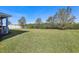 Expansive backyard with lush green lawn, white fence, and mature trees at 10642 Mistflower Ln, Tampa, FL 33647