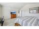 Bright bedroom with a large bed, TV, and an open doorway to another room at 10642 Mistflower Ln, Tampa, FL 33647
