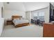 Spacious bedroom with neutral carpet, large windows, a wooden bed frame, and vaulted ceilings at 10642 Mistflower Ln, Tampa, FL 33647