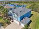 Stunning blue two-story home featuring an attached three-car garage and overlooking a peaceful pond at 10642 Mistflower Ln, Tampa, FL 33647