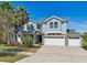 Beautiful two-story home with a three-car garage, stone accents, and lush landscaping at 10642 Mistflower Ln, Tampa, FL 33647