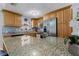 Bright kitchen featuring granite counters, stainless steel appliances, and light wood cabinetry at 10724 Tabor Dr, Tampa, FL 33625