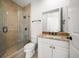 Well-lit bathroom features walk-in shower with glass door and vanity with granite countertop at 11 San Marco St # 307, Clearwater Beach, FL 33767