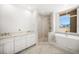 Bright bathroom with a walk-in shower, soaking tub, white marble countertops and cabinetry at 11 San Marco St # 307, Clearwater Beach, FL 33767